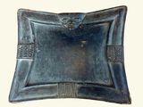 a metal tray with a decorative design on it