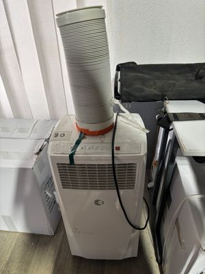 a white air conditioner sitting on top of a white box