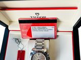 a watch in a box with a red tag on it