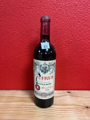 a bottle of red wine sitting on top of a wooden table