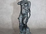statue d'un homme tenant un arc, posée sur un socle dans une pièce