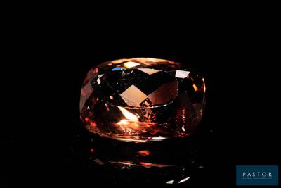 a close up view of a large brown diamond on a black surface