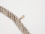 a close up of a chain bracelet with a cross on it