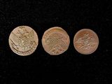 three different types of gold coins on a black surface