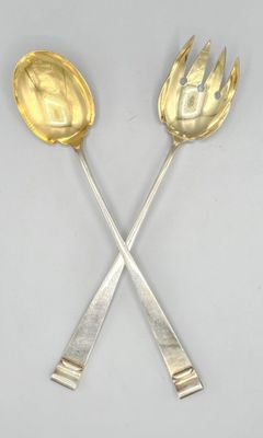 two silver spoons and a fork on a white surface