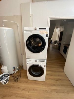 une machine à laver et un sèche-linge placés l'un à côté de l'autre dans une pièce