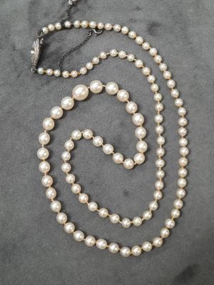 un gros plan d'un collier orné de perles sur un fond gris