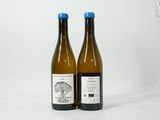 two bottles of wine sitting next to each other on a white surface