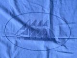 a blue t - shirt with a drawing of a ship on it