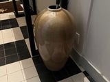 un vase posé par terre dans le couloir