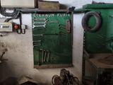 a room with a green door and various tools on the wall