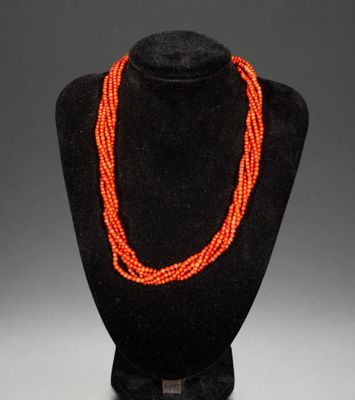 un collier de perles orange sur un mannequin noir