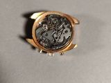 a close up of a watch on a table with a white background