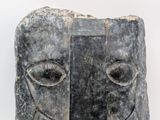 a stone sculpture of a face on a white background