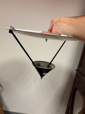 une personne tenant une assiette en carton sur laquelle est dessiné un triangle