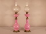 pair of pink glass candlesticks sitting on top of a table