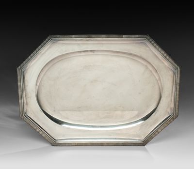 une assiette en argent ornée d'un motif décoratif sur le bord