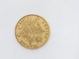 a close up of a gold coin on a white surface