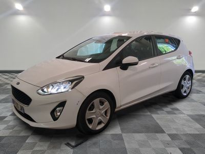 la voiture blanche est garée sur un sol en damier dans le garage