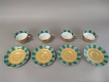 six green and white dishes and cups with gold rims
