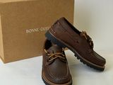 a pair of brown shoes sitting next to a box of brown shoes