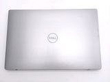 dell laptop computer sitting on a white surface with a dell logo on the screen