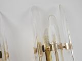 pair of brass and clear glass sconces on a white wall