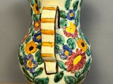 a vase that has flowers painted on it on a table