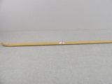 a wooden stick with a red dot on it sitting on a gray surface