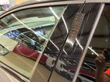 a man taking a picture of his reflection in the window of a car
