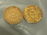 two gold coins sitting on top of each other on a table