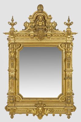 a gold framed mirror with a statue on top of it