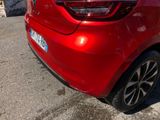 the rear end of a red car parked in a parking lot