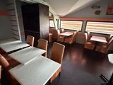 many tables and chairs in a room with windows