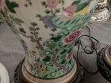 a large vase sitting on a table with a lamp on it