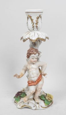 une figurine représentant un garçon tenant un oiseau au-dessus d'un vase