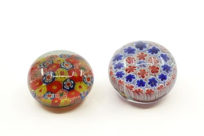 une paire de perles-presse-papiers en verre colorées posées sur une surface blanche