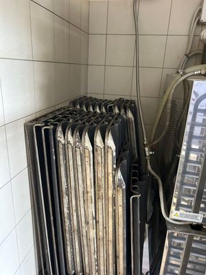 un radiateur dans un coin d'une pièce, sur lequel est posé un téléviseur