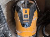 a yellow and black vacuum sitting in a corner of a room