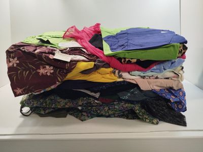 a pile of clothes sitting on top of a white shelf