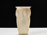 un vase blanc posé sur une table sur fond noir
