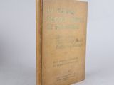 an old book sitting on top of a table on a white surface