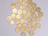 a pile of gold coins on a white surface
