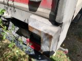 a close up of a truck ' s front bumper with a tree in the background