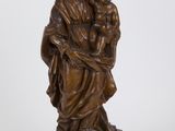 une statue antique en bronze représentant une femme tenant un enfant dans ses bras
