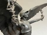 a statue of an angel holding a sword and a shield