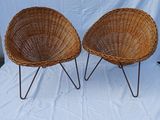 pair of wicker chairs with metal legs on a white background