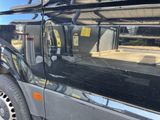 a black truck parked in a parking lot with a yellow sticker on it ' s side