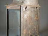 an old metal lantern with a glass door on it