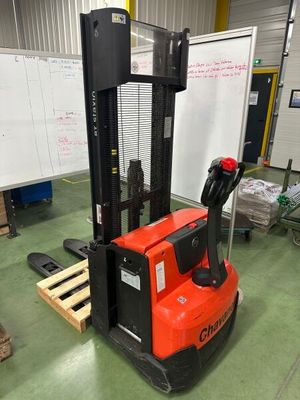 un chariot élévateur rouge dans un entrepôt avec des palettes